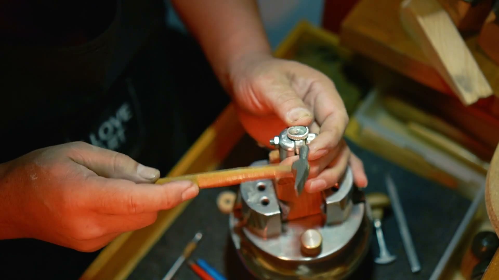 Le mani del maestro al banco mentre mostra una lavorazione